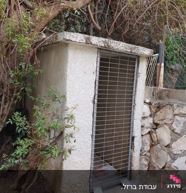 מבנה קטן עם דלת סורגים מתכתית